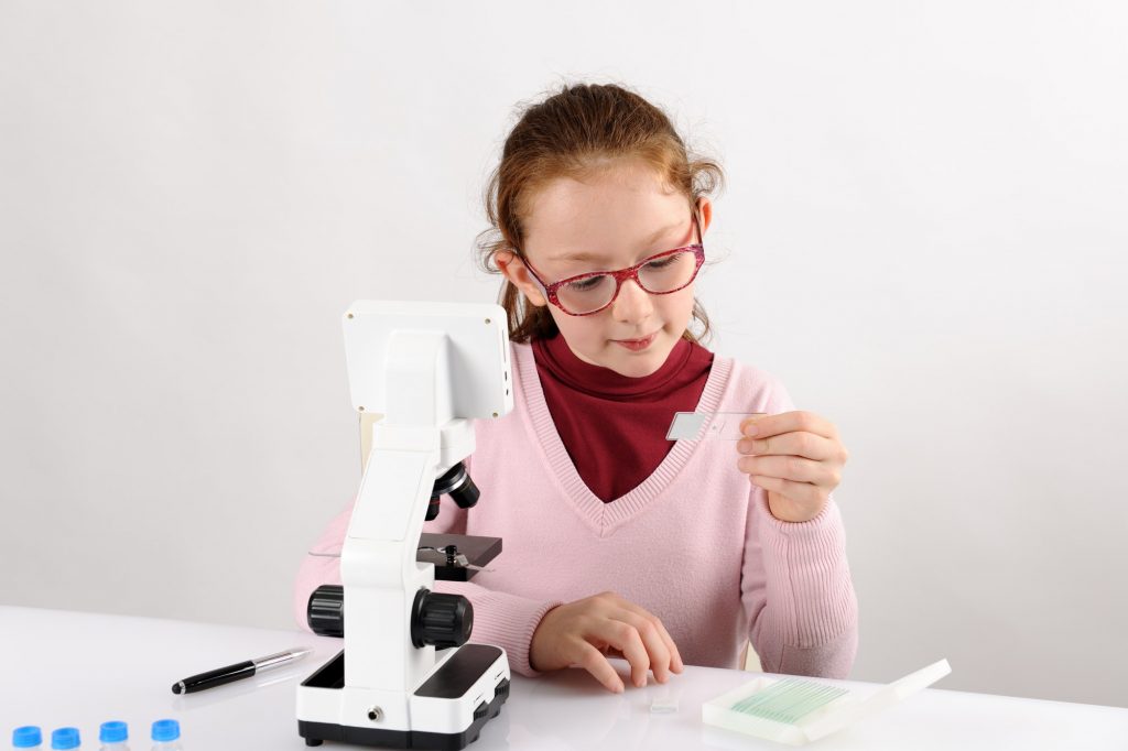 schoolgirl with modern microscope