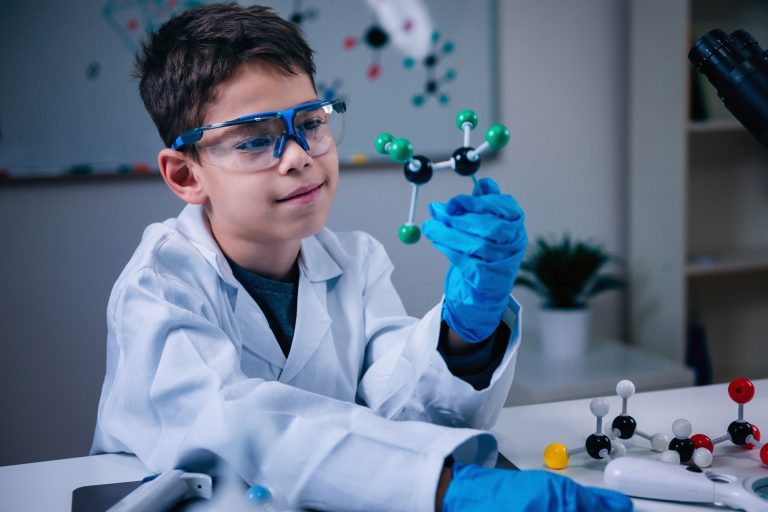 Science education. Cute boy holding molecular model